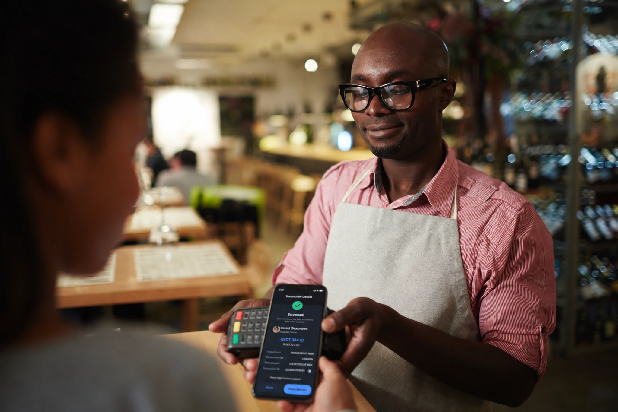 Customer completing a phone payment at a café